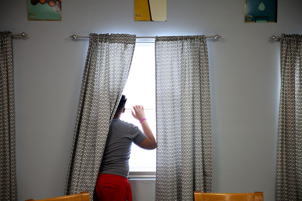 A child staying at Rainbow House looks outside